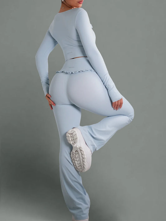 Person wearing a light blue outfit with white sneakers on a gray background