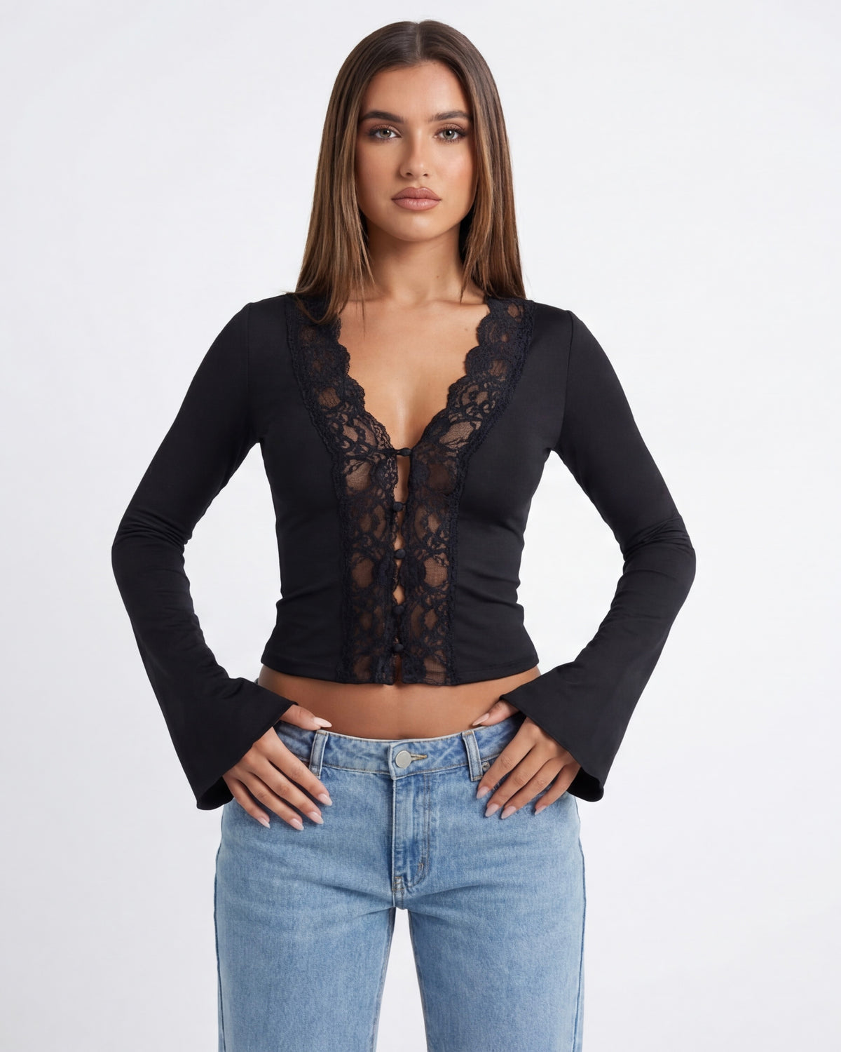 Woman wearing a black lace top and blue jeans on a white background