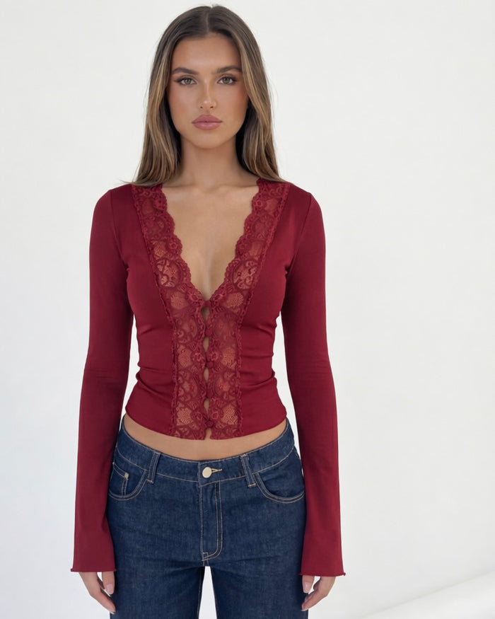 Woman wearing a red lace top and blue jeans on a white background