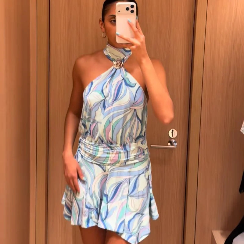 Woman taking a mirror selfie wearing a colorful halter neck dress.