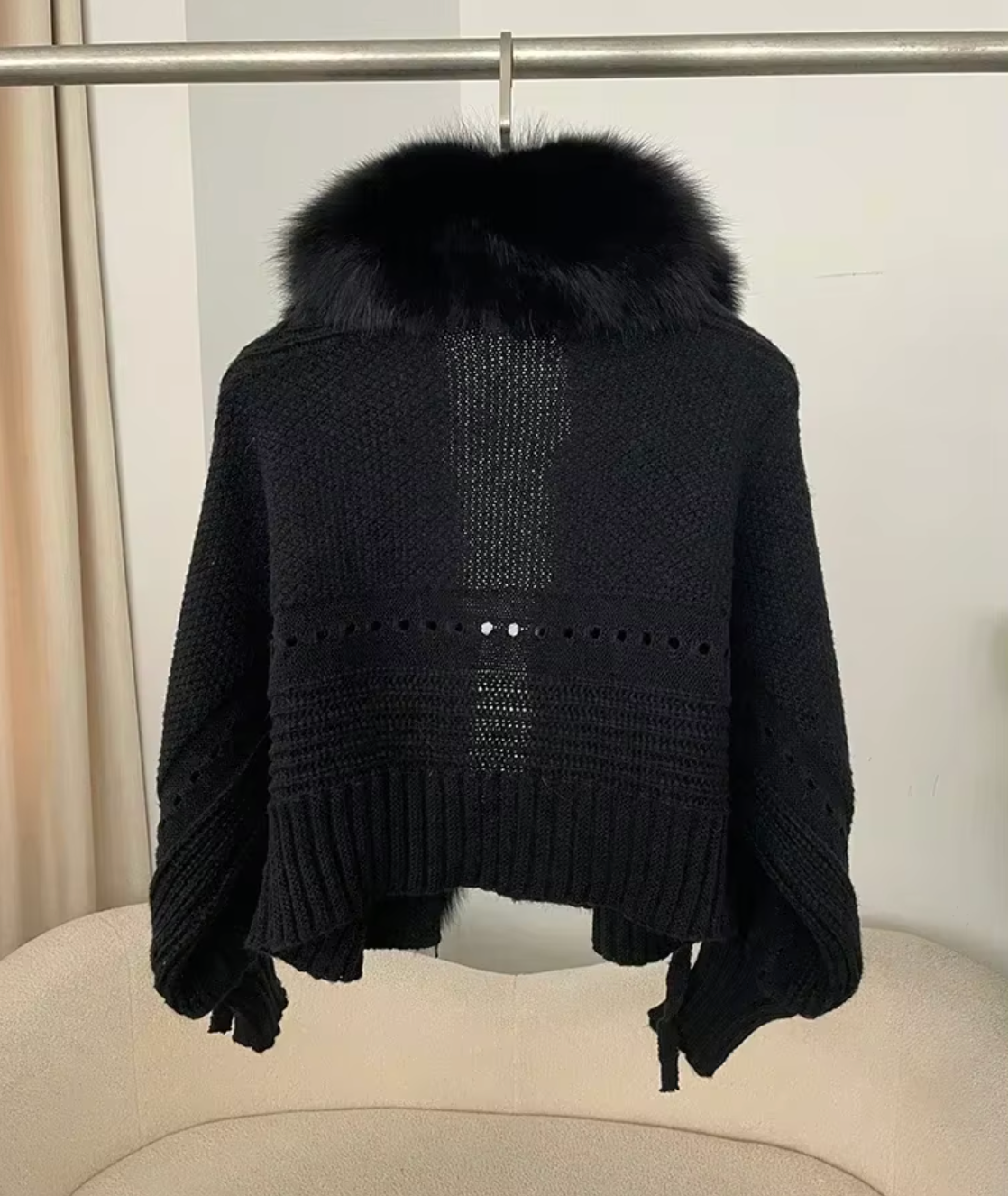Black knit sweater with fur collar on a chair