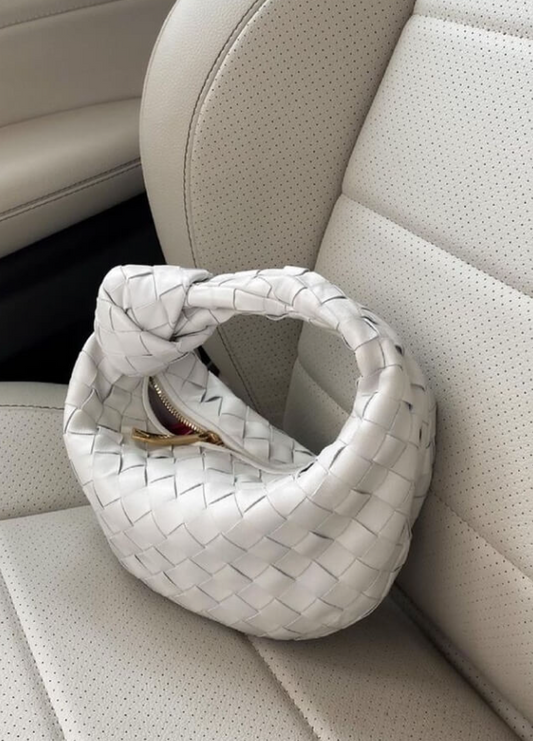White woven handbag on a beige car seat